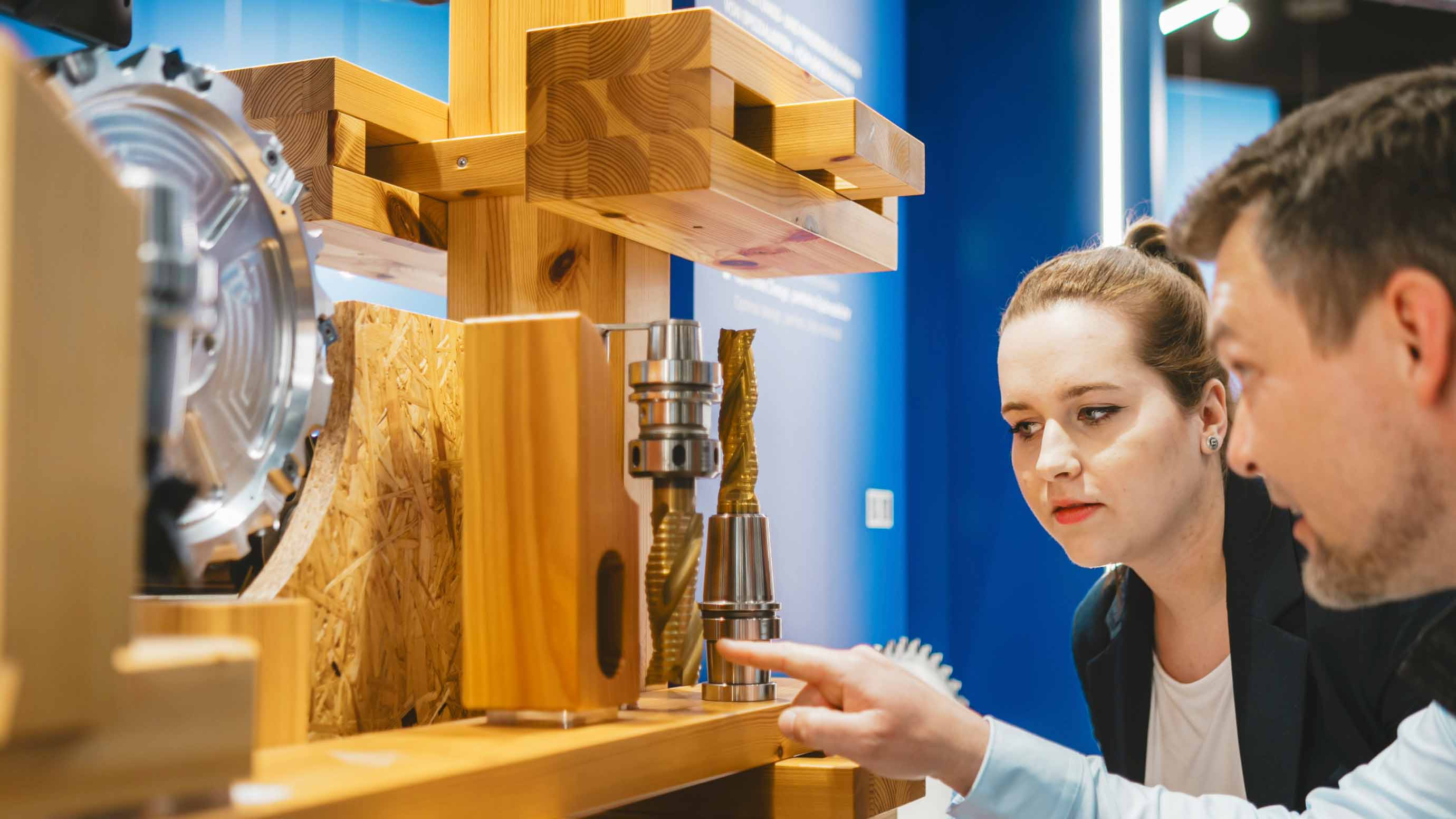 Two people examining a wood cutting machine